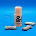Buddycare Oatmeal Paw & Nose Balm 21g stick with lid off, beside dog biscuits
