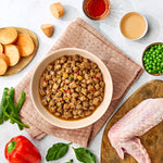 Naturo Turkey in Herb Gravy served in a bowl with turkey, sweet potato, peas and peppers